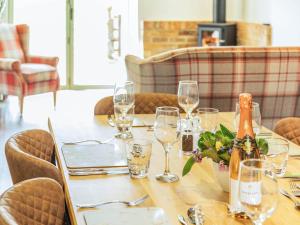 a table with wine glasses and a bottle on it at The Old Stables - Uk37000 in Ridlington