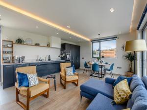 a living room with a blue couch and chairs at Buttercup Lodge - Uk36655 in Boothby Pagnell