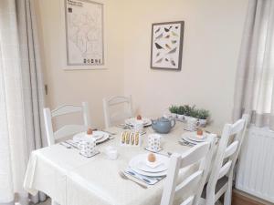 a white table with white chairs and a white table cloth at Alpine Cottage in Carperby