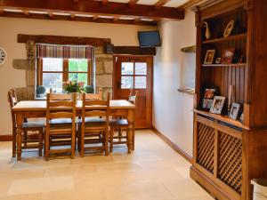 a dining room with a wooden table and chairs at Flatts Barn in Hebden