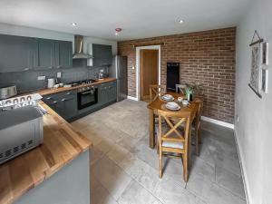 a kitchen with green cabinets and a wooden table at No 3 Rabbit Warren-Uk44299 in Lenwade