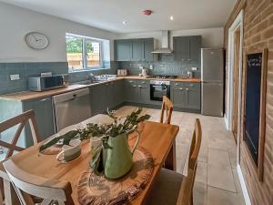 a kitchen with a wooden table with a vase on it at No 3 Rabbit Warren-Uk44299 in Lenwade