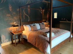 a bedroom with a canopy bed and a blue wall at The Richmond - Uk40459 in Newsham +13 photos