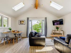 a living room with two couches and a table at Barn Owls Rest in Clyro