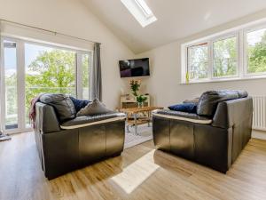two leather chairs in a living room with windows at Barn Owls Rest in Clyro +33 photos