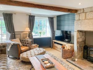 a living room with a couch and a fireplace at Hob Cote - Cottage in Heptonstall