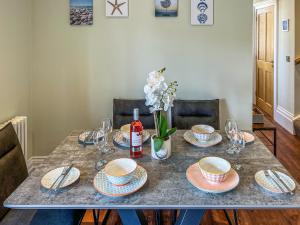 a table with plates and glasses and a bottle of wine at Old School Mews Too in Shanklin
