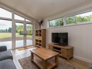 a living room with a television and a table at Oak Lodge in Hassocks