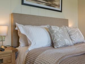 a bedroom with a bed with white pillows at Oak Lodge in Hassocks