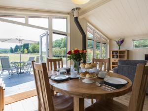 a dining room with a wooden table with food on it at Oak Lodge in Hassocks +11 photos