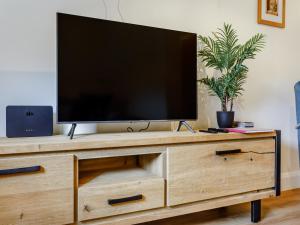 a television on top of a wooden entertainment center at Woodpecker Barn - Uk38613 in Wisbech +25 photos