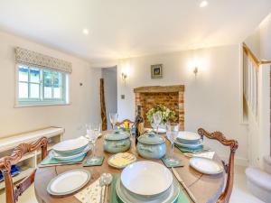a dining room with a table and chairs and a fireplace at Halton Lodge in Halton Holegate