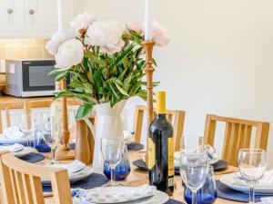 a table with a bottle of wine and a vase of flowers at Limber Wold House in Great Limber