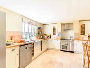 a kitchen with white cabinets and stainless steel appliances at Limber Wold House in Great Limber +28 photos