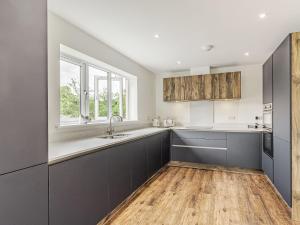a kitchen with gray cabinets and a sink at Kings Lodge in Neatishead +25 photos