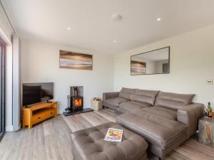 a living room with a couch and a television at Goppa in Llanfair