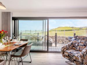 a living room with a table and chairs and a large window at Goppa in Llanfair