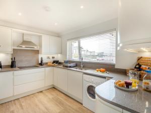 a kitchen with white cabinets and a dishwasher at Goppa in Llanfair