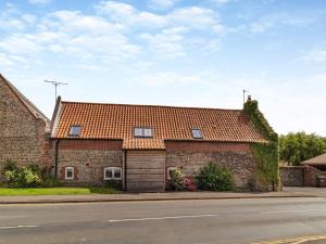 a brick house with an orange roof on a street at The Old Barn in Mundesley