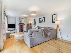 a living room with a couch and a tv at The Old Barn in Mundesley