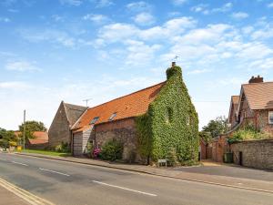 a building covered in ivy on the side of a street at The Old Barn in Mundesley +10 photos