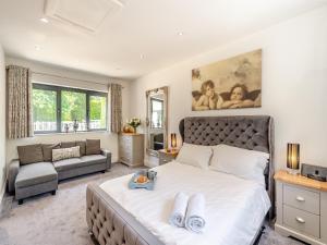 a bedroom with a large bed and a couch at Foxton Lodge - Uk47296 in Harrietsham