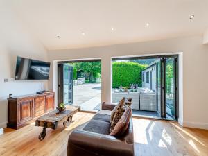a living room with a couch and a tv at Foxton Lodge - Uk47296 in Harrietsham