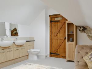 a bathroom with a toilet and a wooden door at Clawdd Gwyn in Llanrwst +20 photos