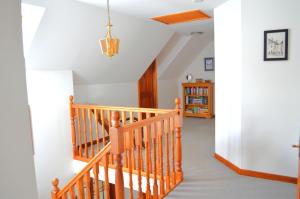 a staircase in a home with white walls and a wooden railing at Auburn Cottage in Arbroath