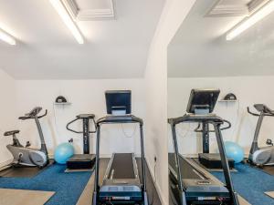a gym with several treadmills and exercise bikes at Y Bwthyn-Oxm in Gwynfe