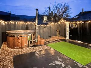 a backyard with a gazebo and a green lawn at Logiemar Cottage in Ballater