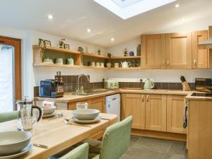 a kitchen with wooden cabinets and a table with chairs at Logiemar Cottage in Ballater +12 photos