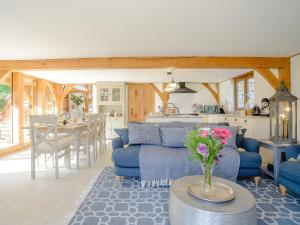 a living room with blue couches and a kitchen at Hare's Furrow - Uk12607 in Burton Overy