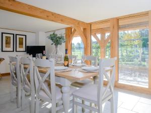 a dining room with a table and white chairs at Hare's Furrow - Uk12607 in Burton Overy