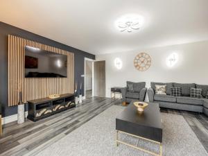 a living room with a couch and a tv at Cowslip Cottage - Uk47072 in Maltby le Marsh