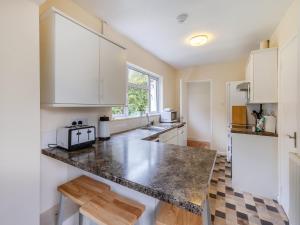 a kitchen with white cabinets and a counter top at Spruce Cottage - Uk46875 in Hartland