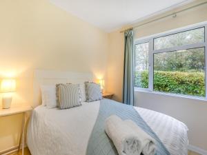 a white bedroom with a bed and a window at Spruce Cottage - Uk46875 in Hartland +16 photos