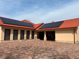 a building with solar panels on the roof at Tóth Vendégház in Nagykálló