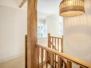 a hallway with a wooden staircase with a chandelier at Sandstones in Niton