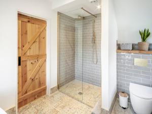 a bathroom with a shower with a wooden door at Sandstones in Niton