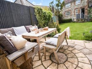 a patio with a wooden table and two chairs at Sandstones in Niton