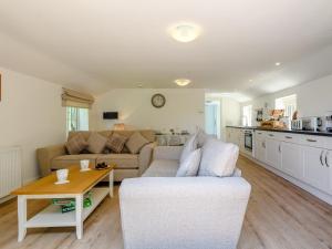 a living room with a couch and a table at The Chicken Coop in Fulletby