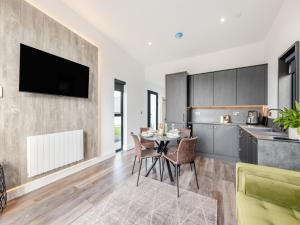 a kitchen and dining room with a table and chairs at Seiriol Lodge 4 - Uk42794 in Llangefni