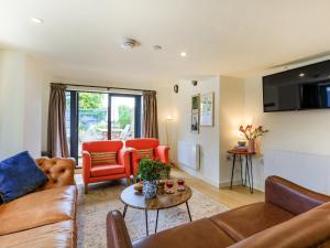 a living room with a couch and chairs and a table at Coach House - Uk32202 in Burton Bradstock