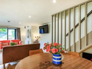 a living room with a table with flowers on it at Coach House - Uk32202 in Burton Bradstock
