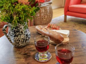 a wooden table with two glasses of wine and bread at Coach House - Uk32202 in Burton Bradstock