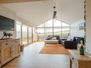 a living room with a couch and a tv at Tyr Ywen Cottage in Abergavenny