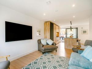 a living room with two chairs and a flat screen tv at Puckoo's Nest in Newquay