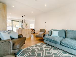 a living room with two couches and a kitchen at Puckoo's Nest in Newquay
