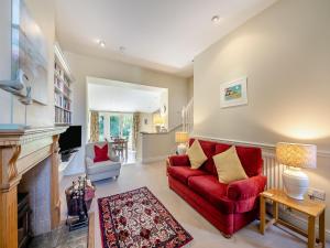 a living room with a red couch and a fireplace at Shellrigg - Uk49891 in Preston